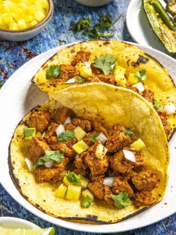 Tacos al Pastor served on toasted corn tortillas