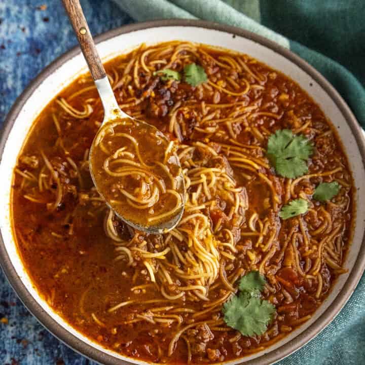 Spicy Mexican fideo soup in a bowl with a spoon, ready to serve
