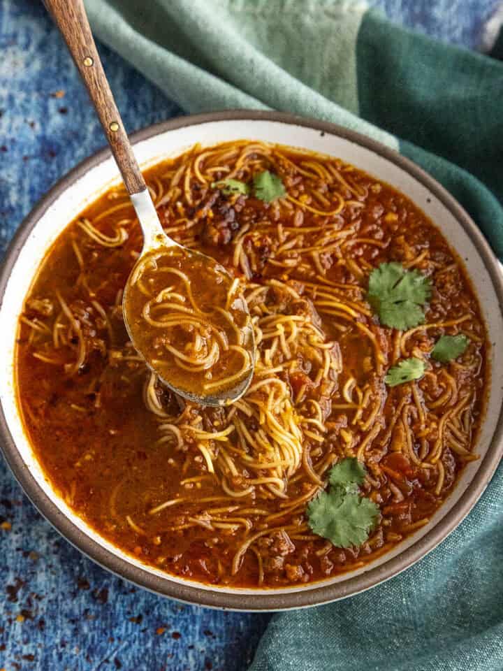 Spicy Mexican fideo soup in a bowl with a spoon, ready to serve