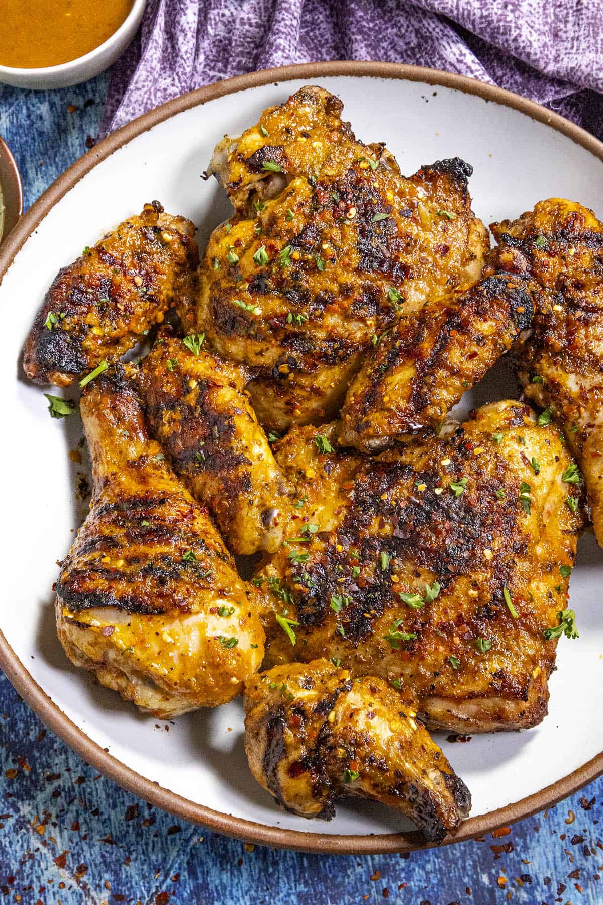 Peri Peri Chicken on a plate, ready to serve with extra peri peri sauce on the side