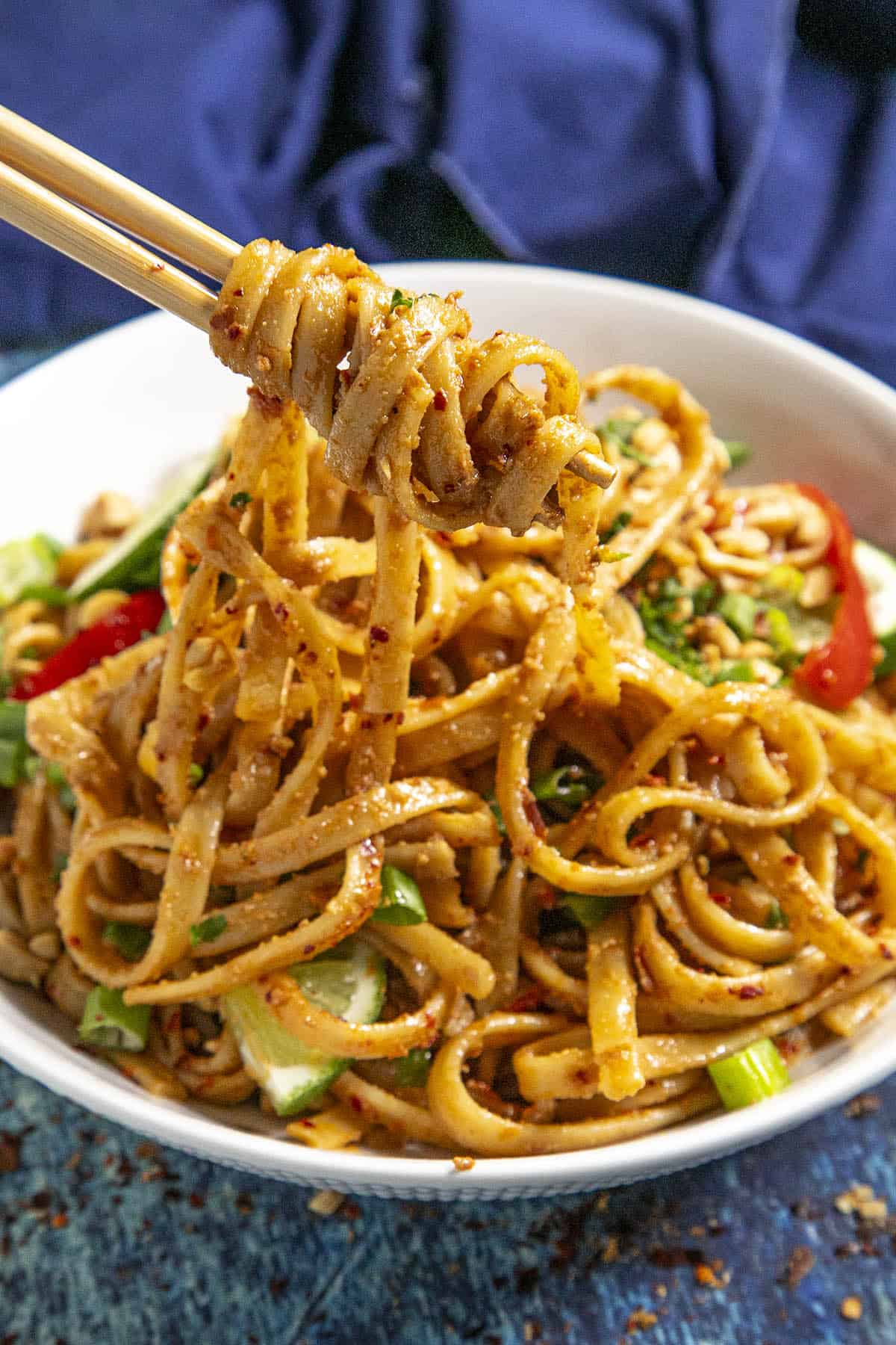 Mike scooping up Thai Peanut Noodles from a bowl with chopsticks