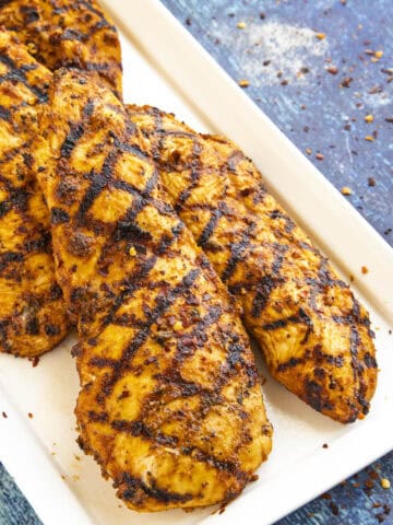 Perfectly grilled chicken on a plate, so juicy and moist from the chicken marinade
