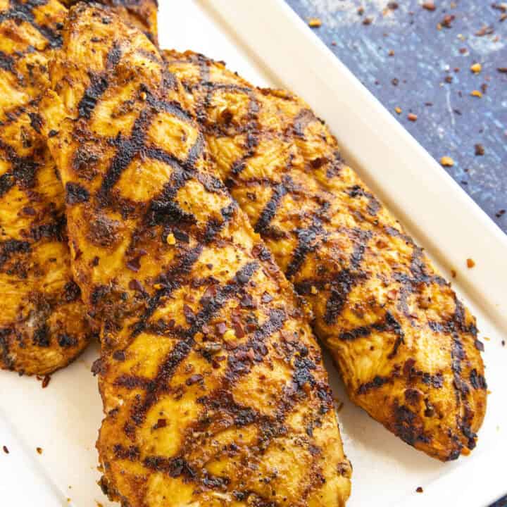 Perfectly grilled chicken on a plate, so juicy and moist from the chicken marinade