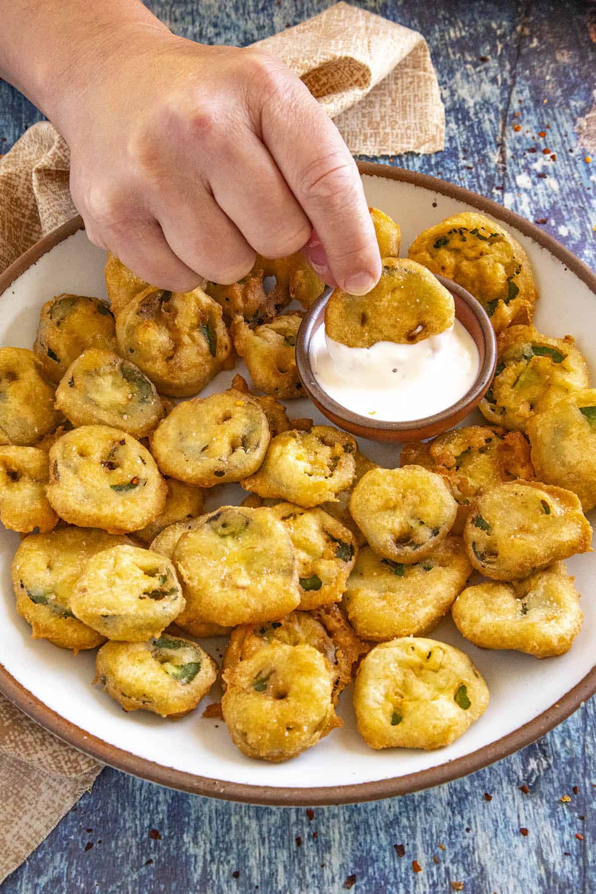 Mike dipping a fried jalapeno slice into a creamy dressing