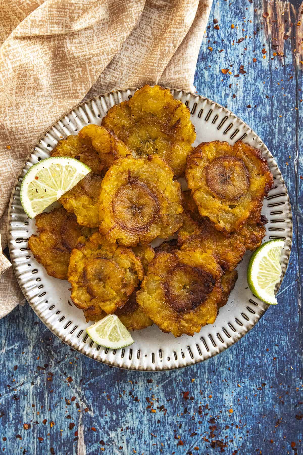 Tostones on a plate with lime wedges, ready to eat