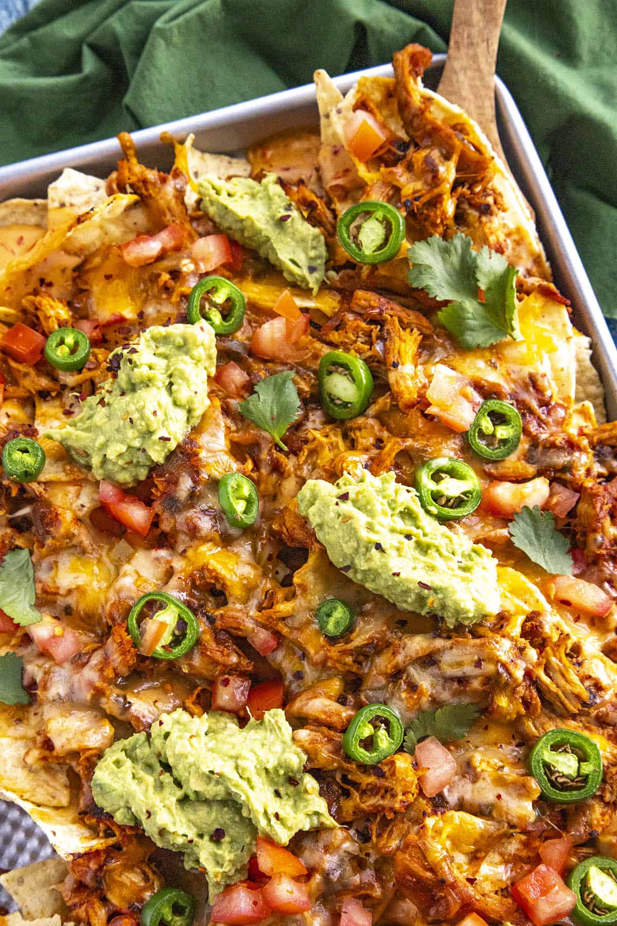 Mike serving a big scoop of chicken nachos from the baking sheet