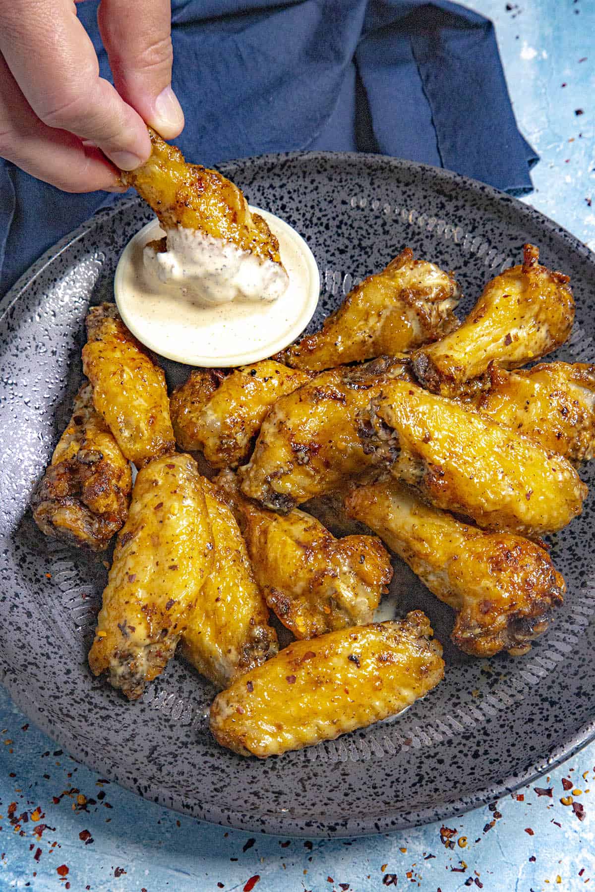 Mike dipping a juicy chicken wing into a bowl of Alabama white bbq sauce