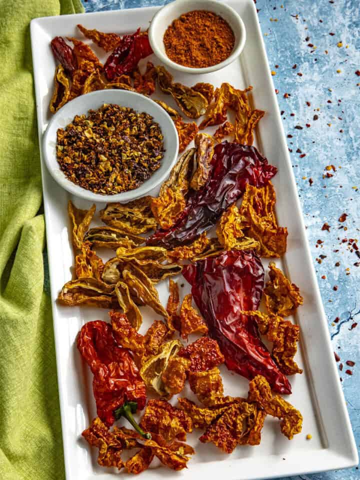 A Colorful Collection of Dehydrated chili peppers, chili flakes, and chili powder on a platter