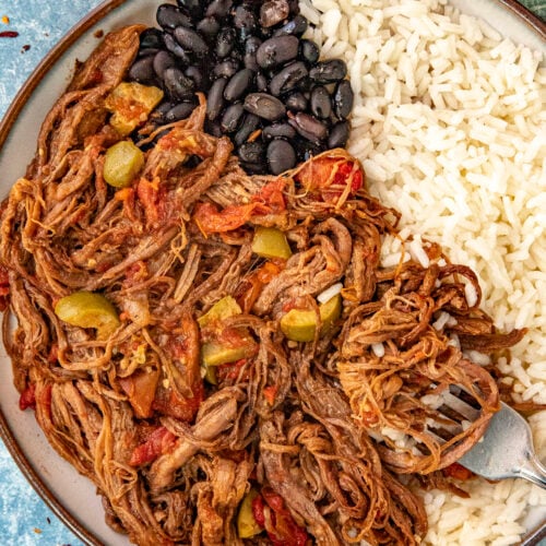 Ropa Vieja (Cuban Shredded Beef) in a bowl with rice and black beans