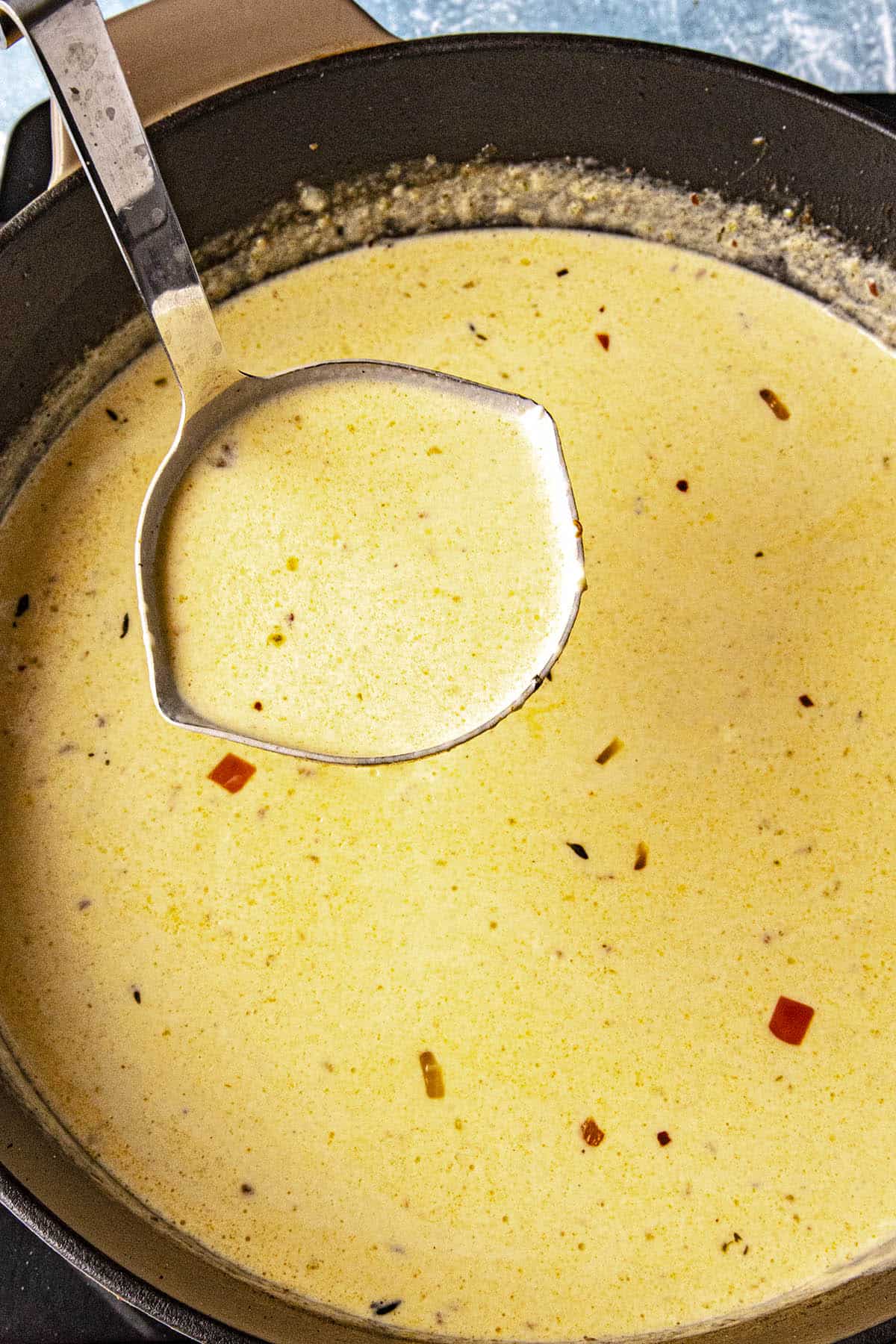 Mike scooping a ladle of Beer Cheese Soup from the pot