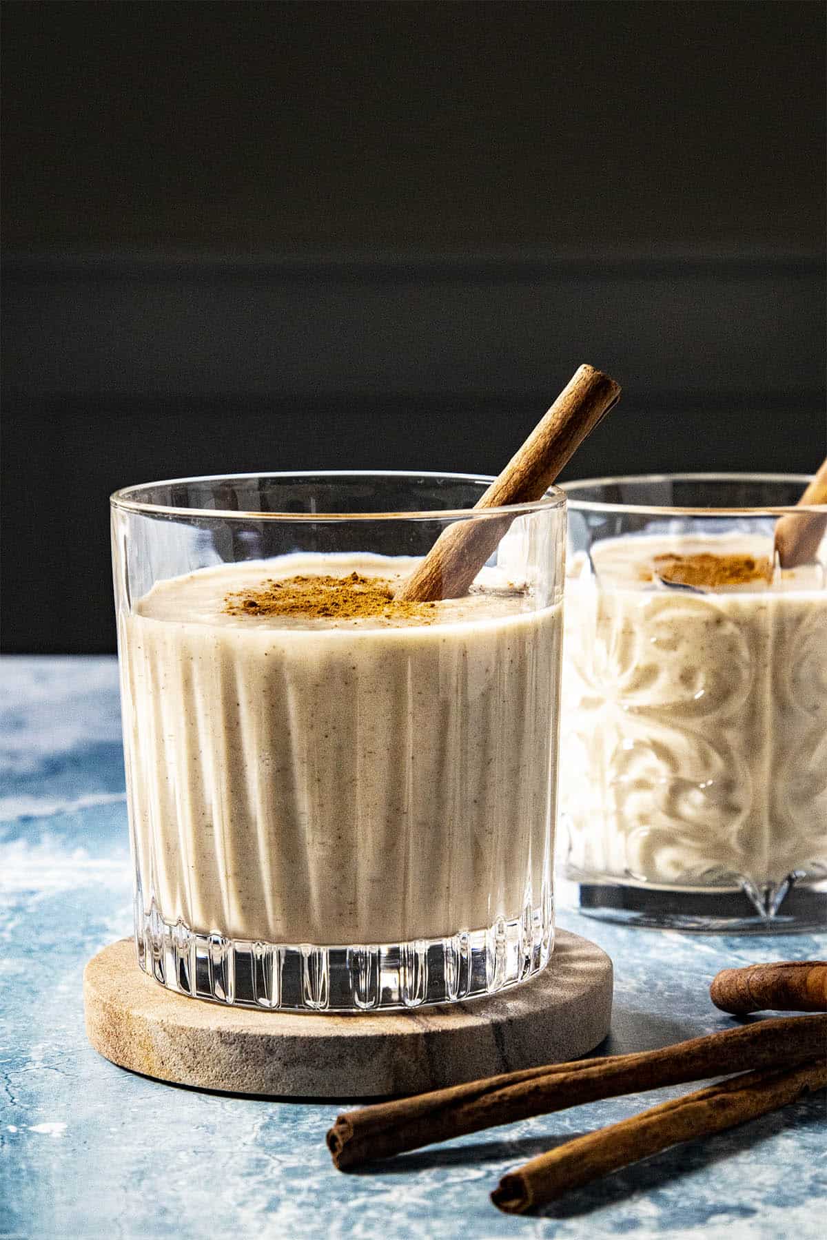 Coquito in a glass with cinnamon garnish