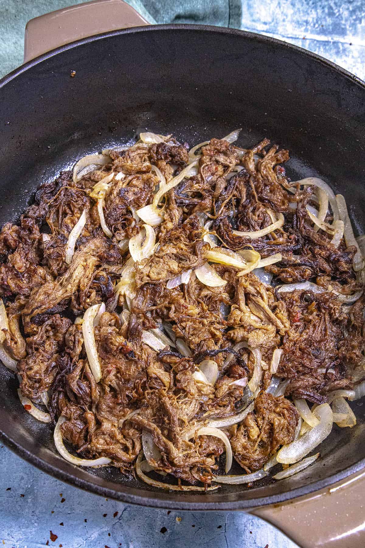 Cuban fried beef (Vaca Frita) in a pan with lots of onions