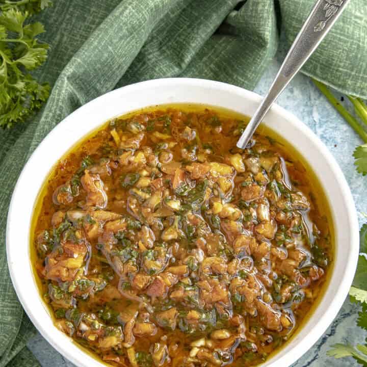 Red Chimichurri (Chimichurri Rojo) in a bowl with a serving spoon