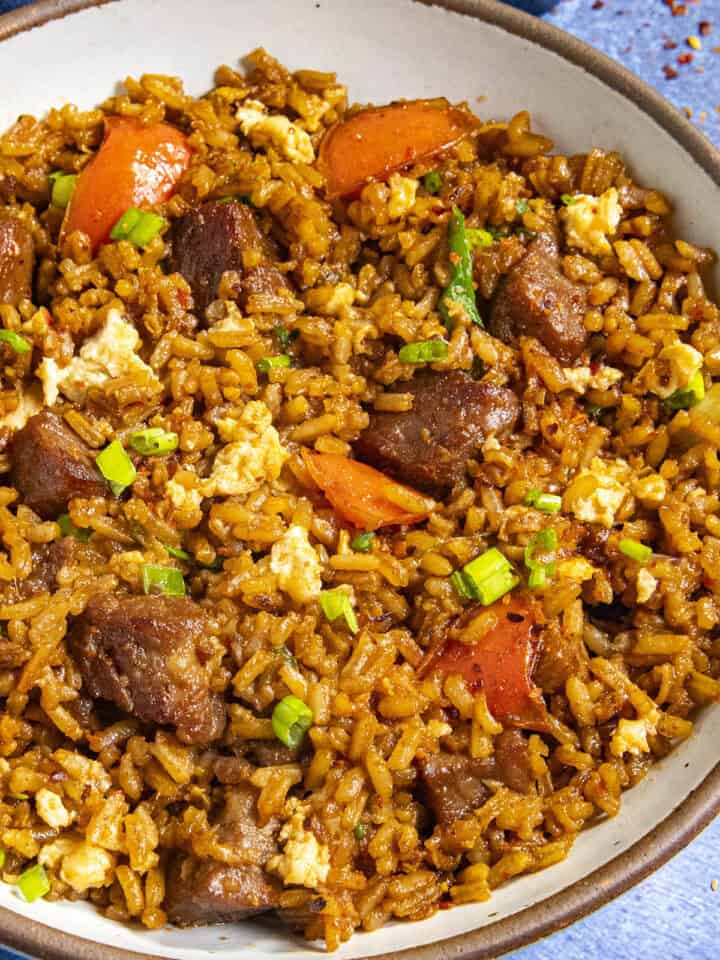 A bowl of Steak Fried Rice with lots of sizzling beef
