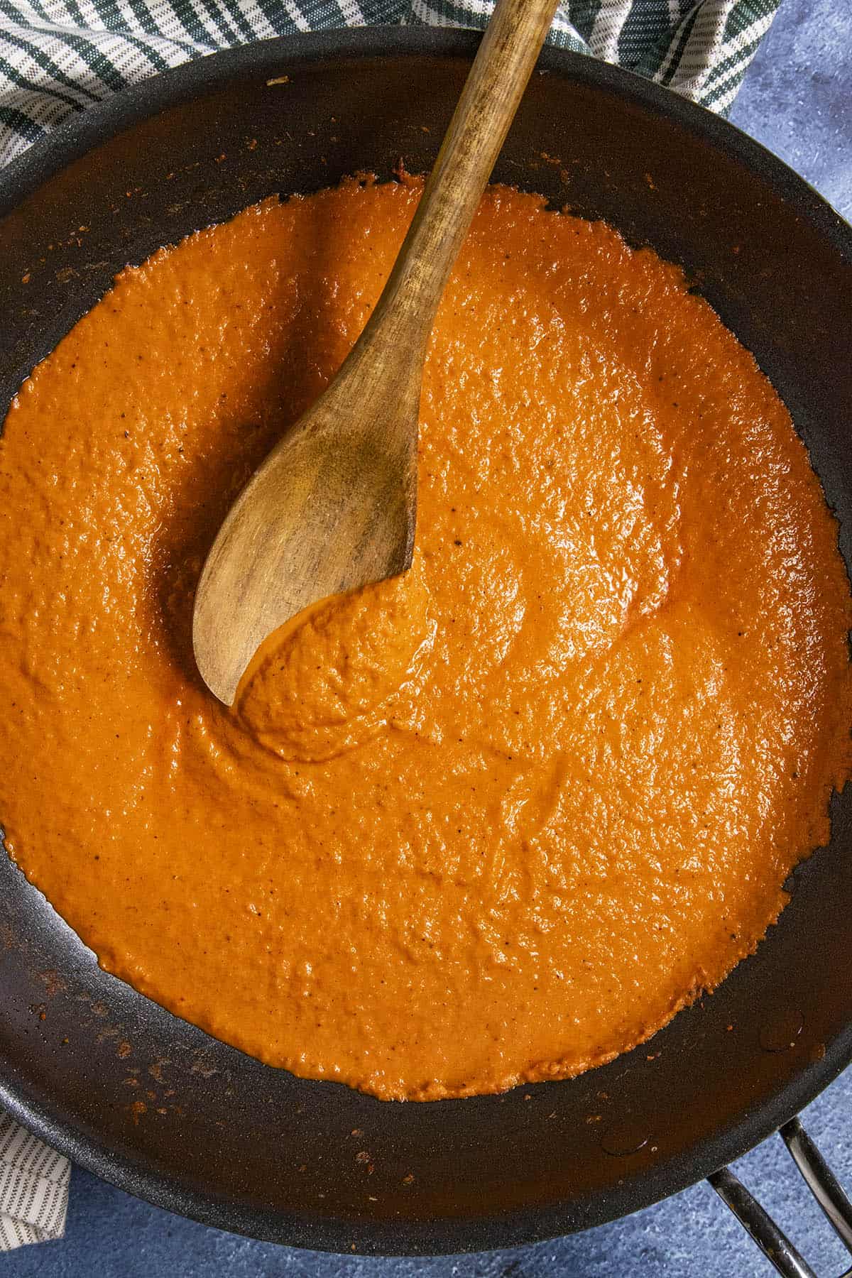 Serving a spoonful of Roasted Red Pepper Sauce from the pan