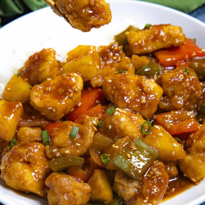 Mike taking a piece of Sweet and Sour Chicken from the bowl