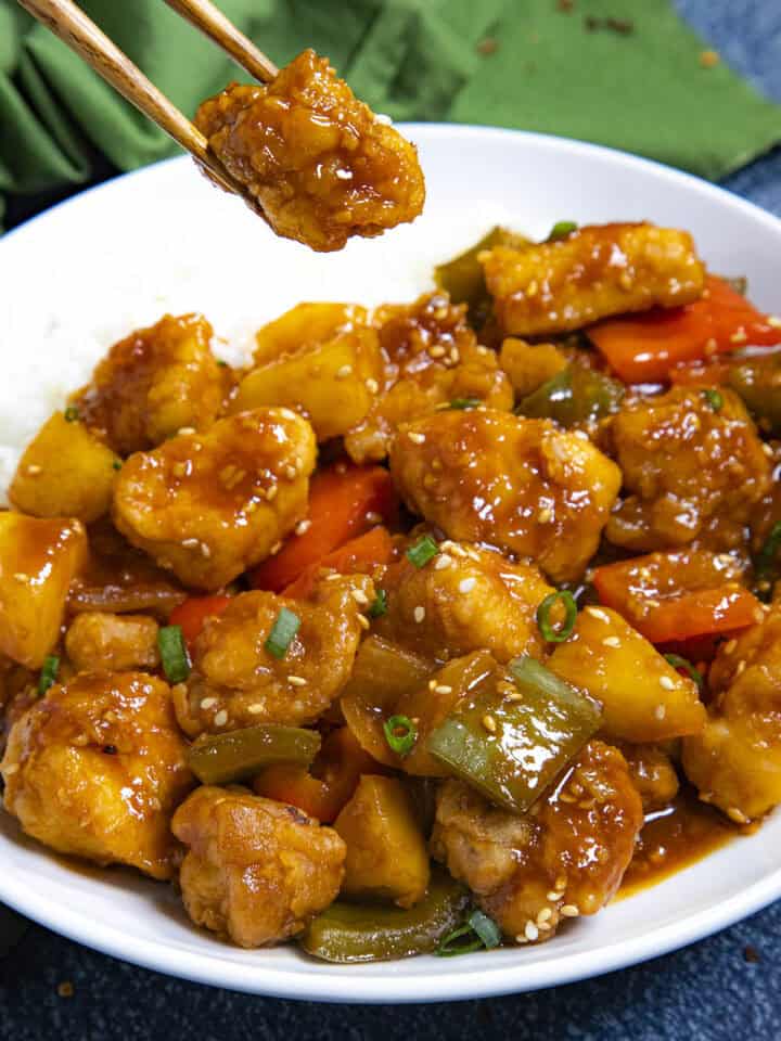 Mike taking a piece of Sweet and Sour Chicken from the bowl
