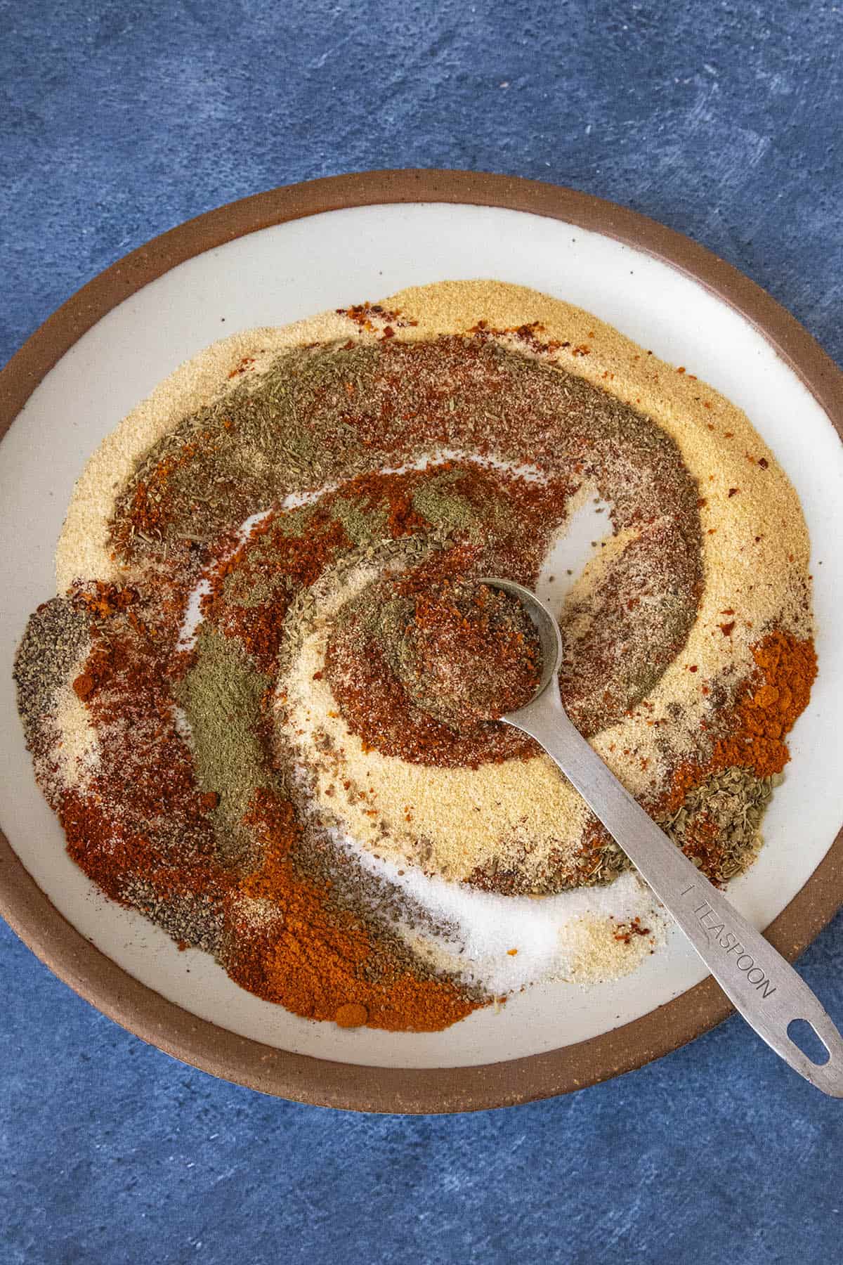 Swirling Beef Stew Seasoning ingredients together in a bowl