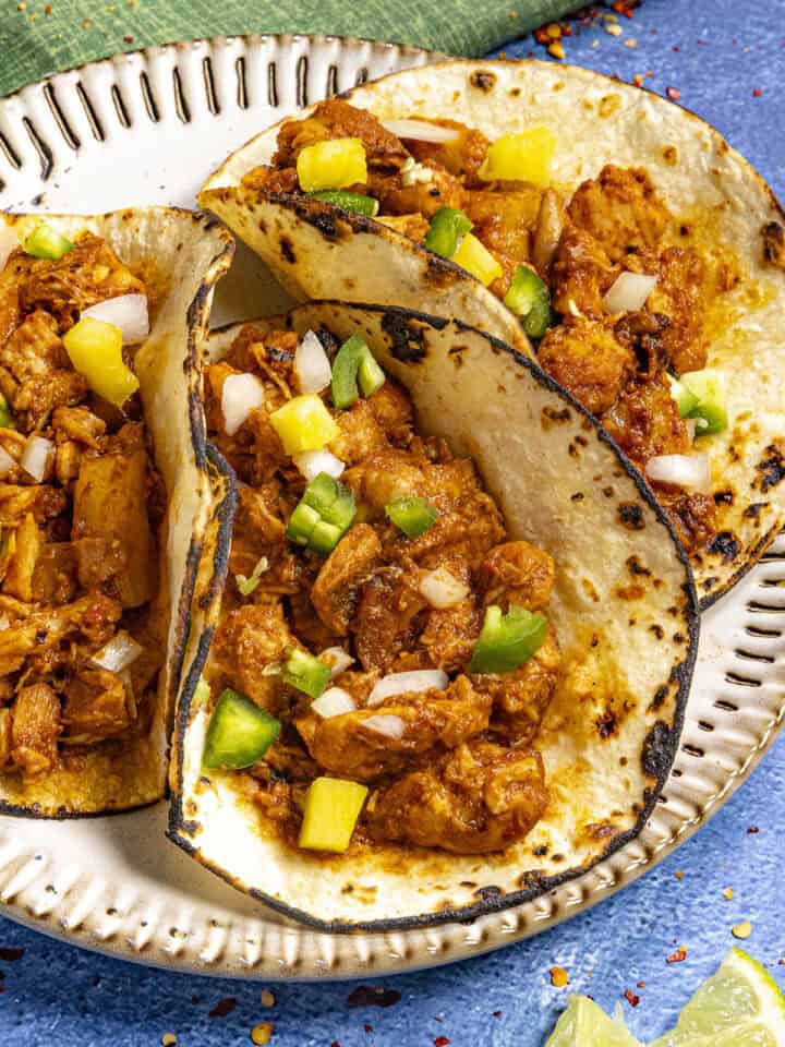 3 Chicken al Pastor tacos on a plate, ready to be enjoyed.