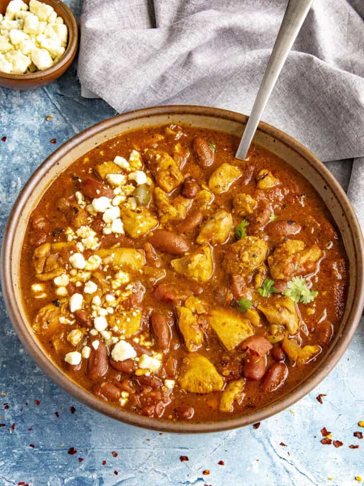 A large bowl of spicy Buffalo Chicken Chili with blue cheese crumbles on top