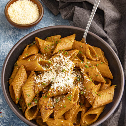 Zesty Gochujang Pasta in a bowl with grated Parmesan cheese on top