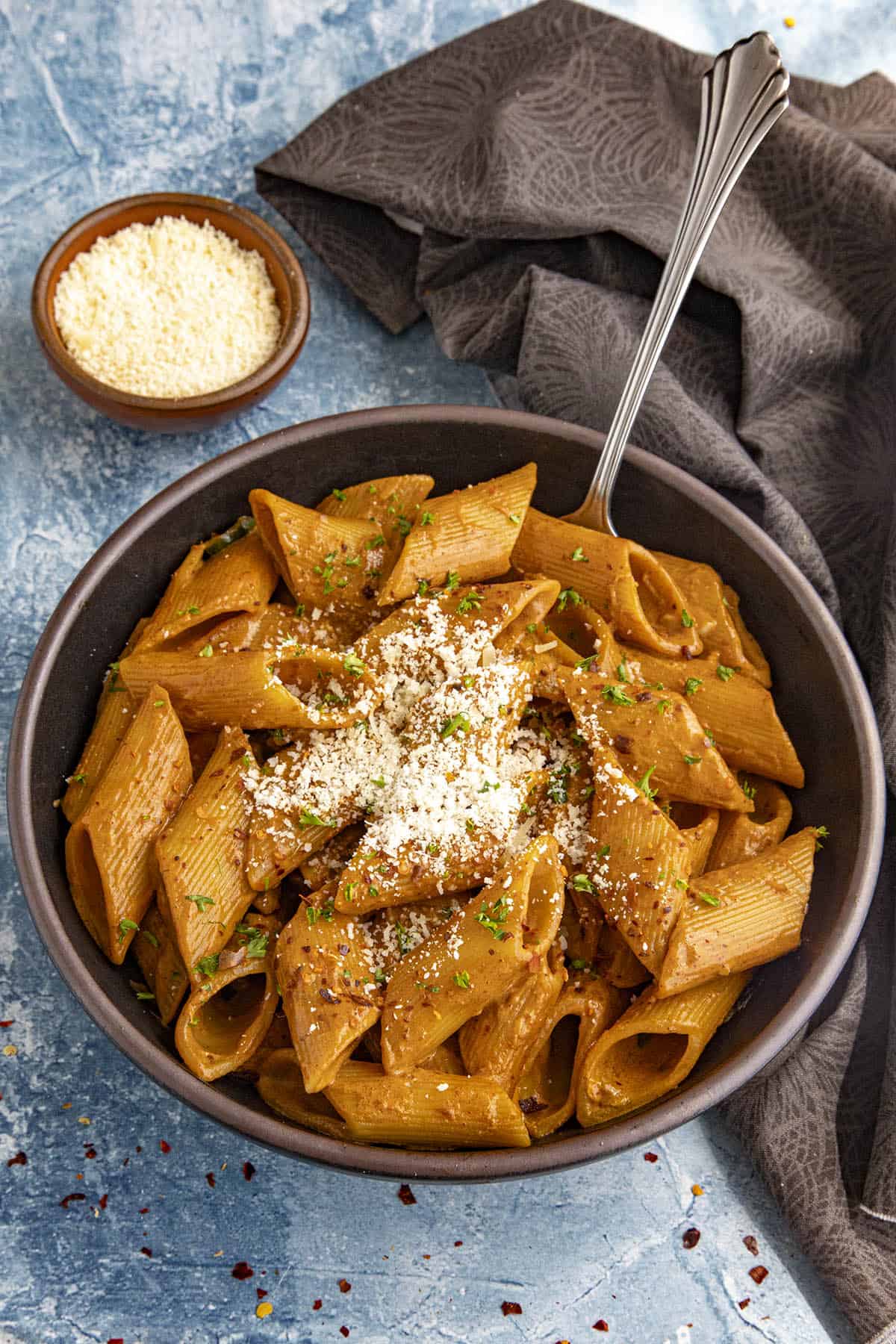 Zesty Gochujang Pasta in a bowl with grated Parmesan cheese on top
