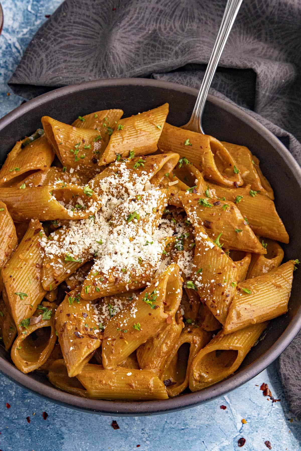 Gochujang Pasta in a bowl, garnished with grated Parmesan cheese