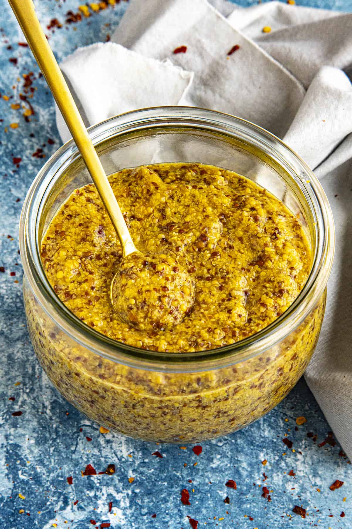 A jar of spicy Homemade Honey Beer Mustard with a serving spoon