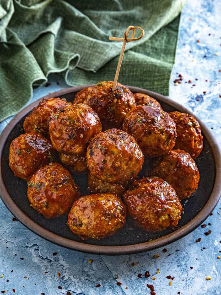Honey Sriracha Meatballs served on a plate drizzled with extra glaze