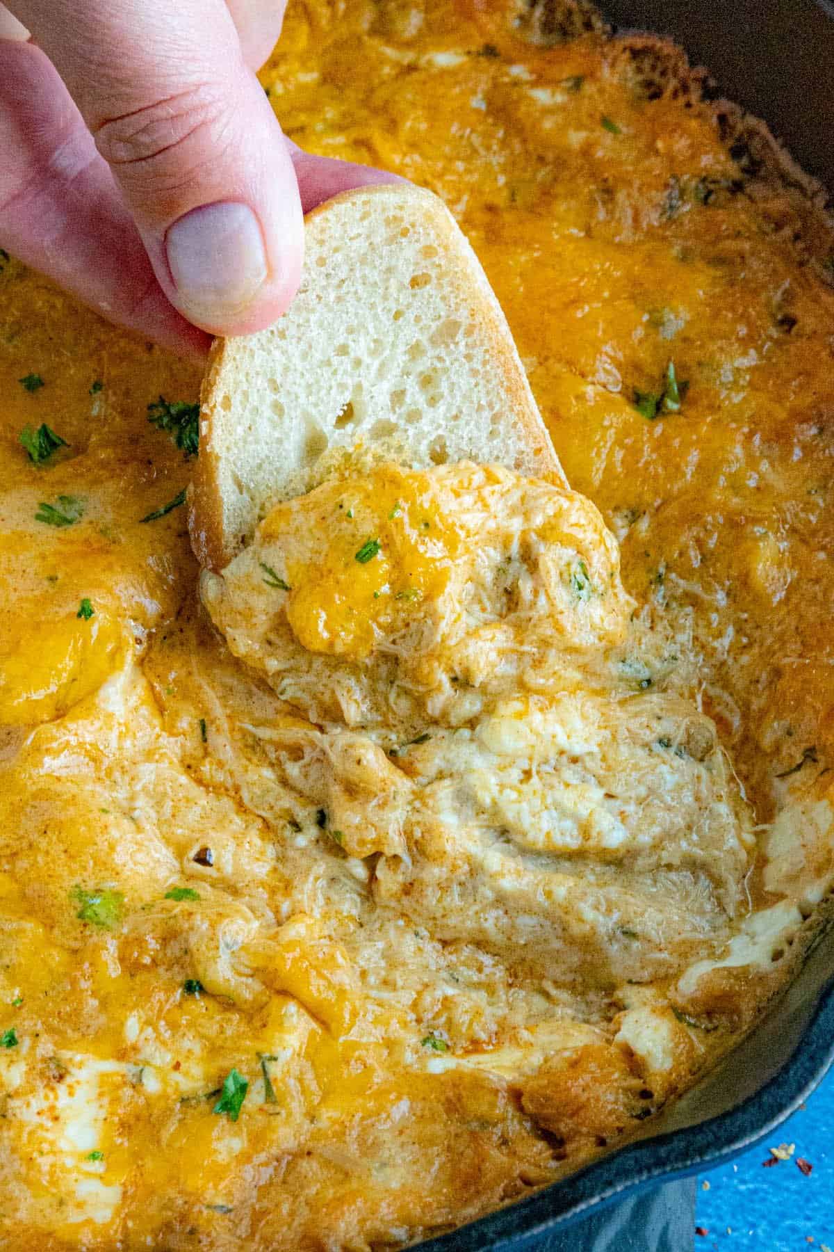 Mike Taking a scoop from the pan of hot crab dip with a crostini