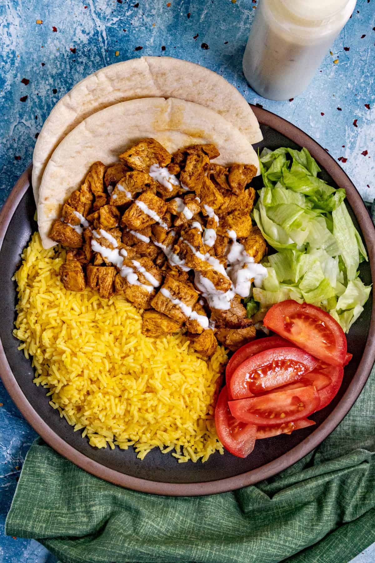 Halal Cart Style Chicken served on a plate, drizzled with Halal white sauce