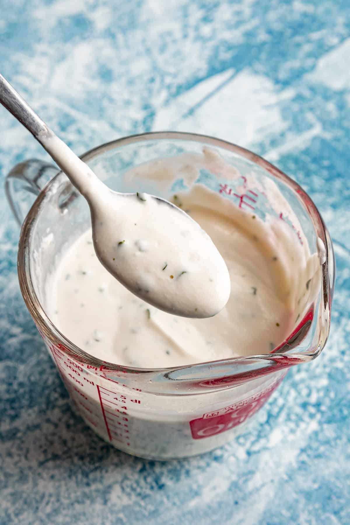 Mixing Halal White Sauce in a mixing cup