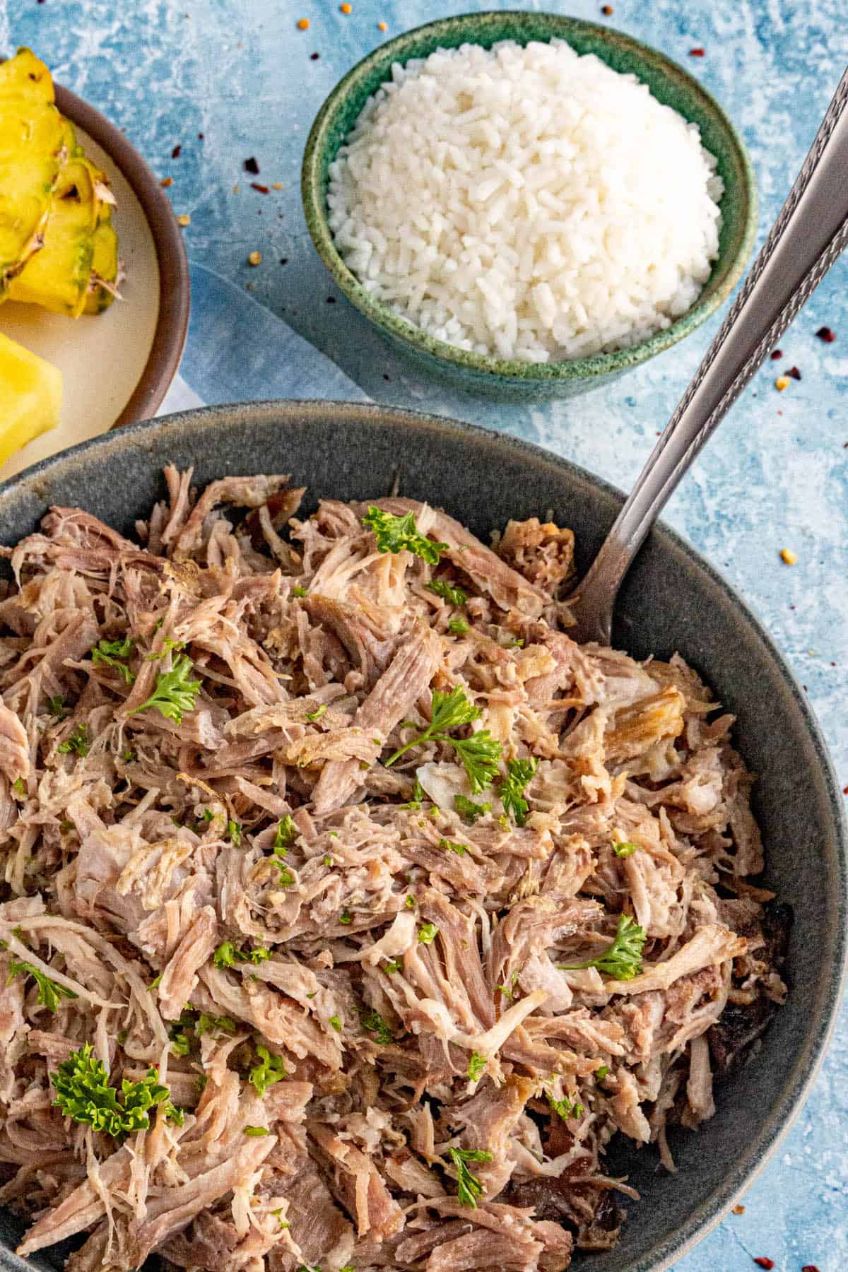 A large bowl of Kalua Pork, ready to serve, with steamed rice on the side
