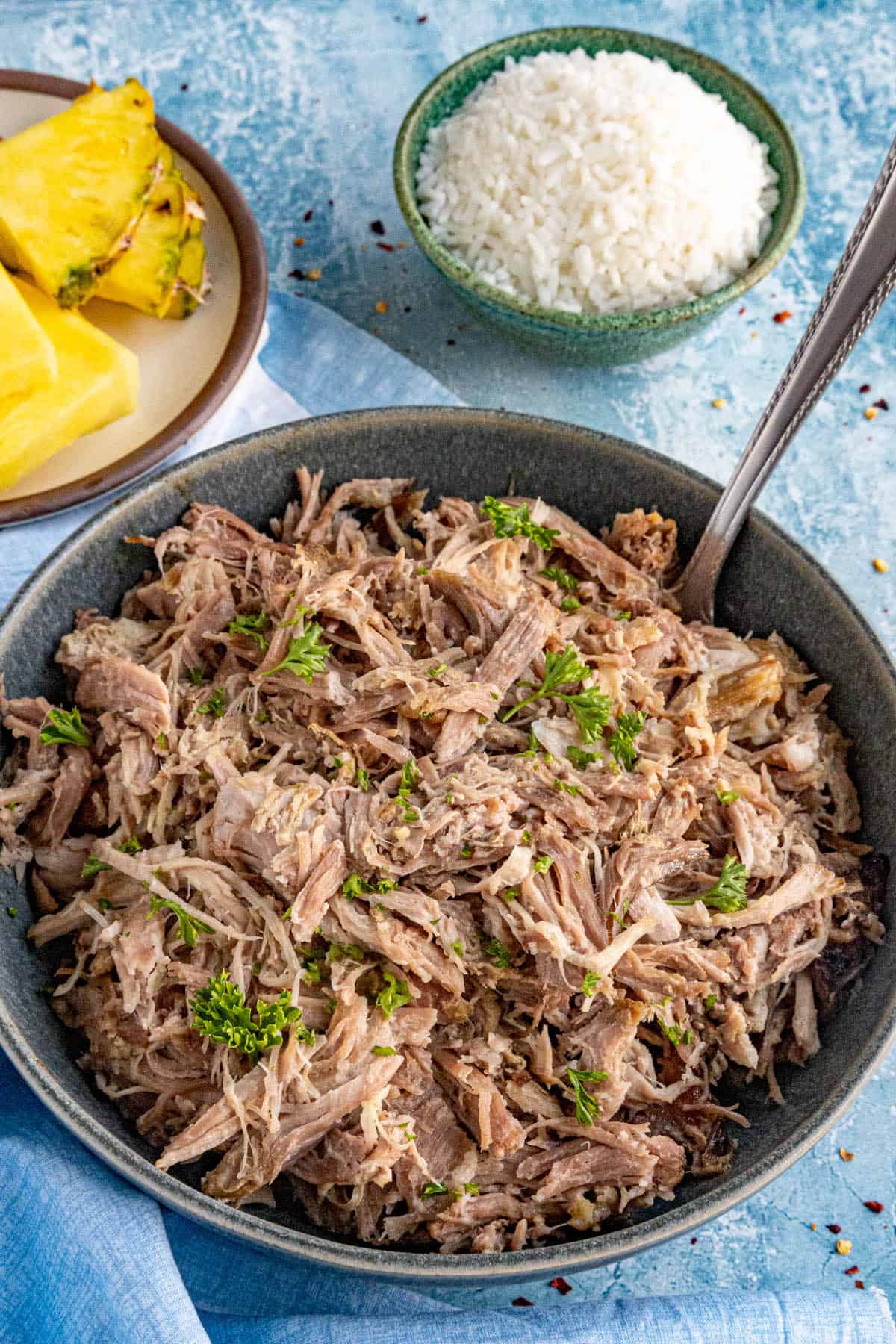 A large bowl of Kalua Pork, ready to serve, with steamed rice on the side