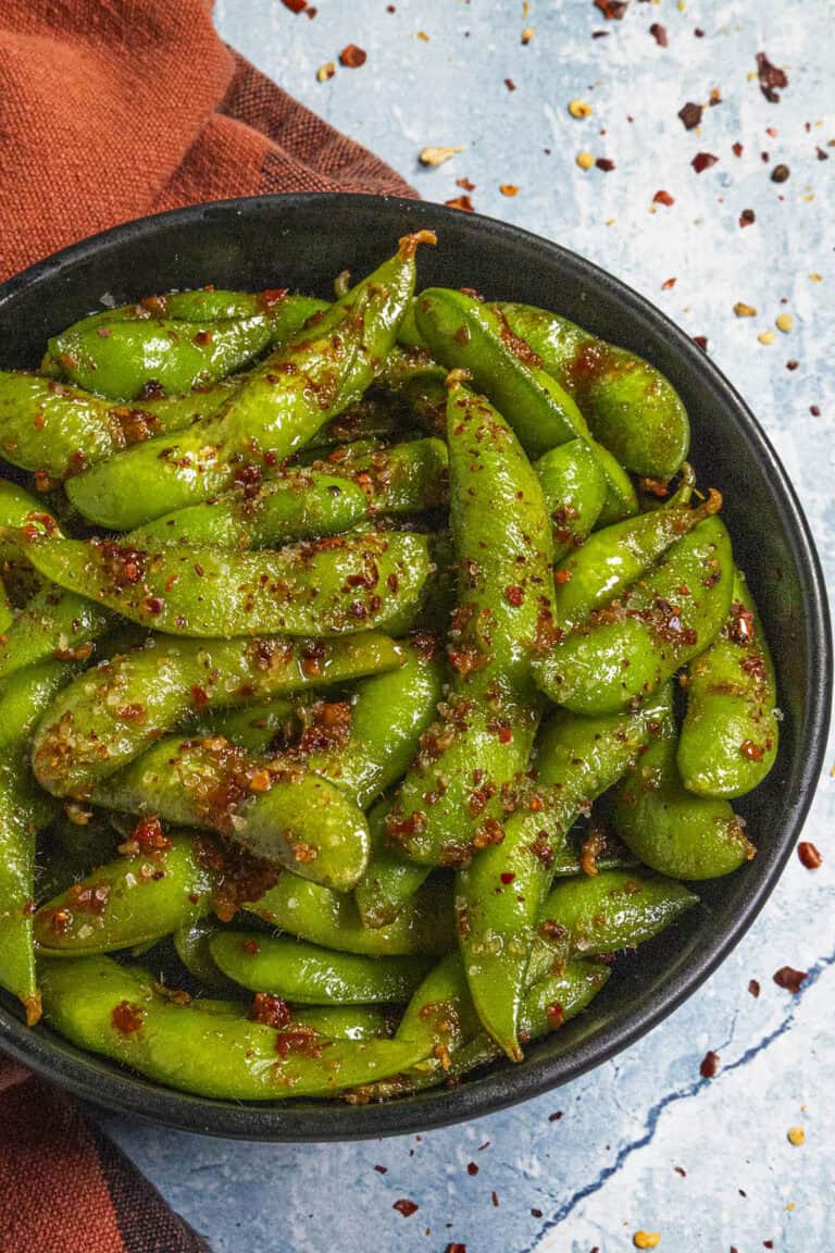 Spicy Edamame served in a bowl with a fiery dressing and chili flakes