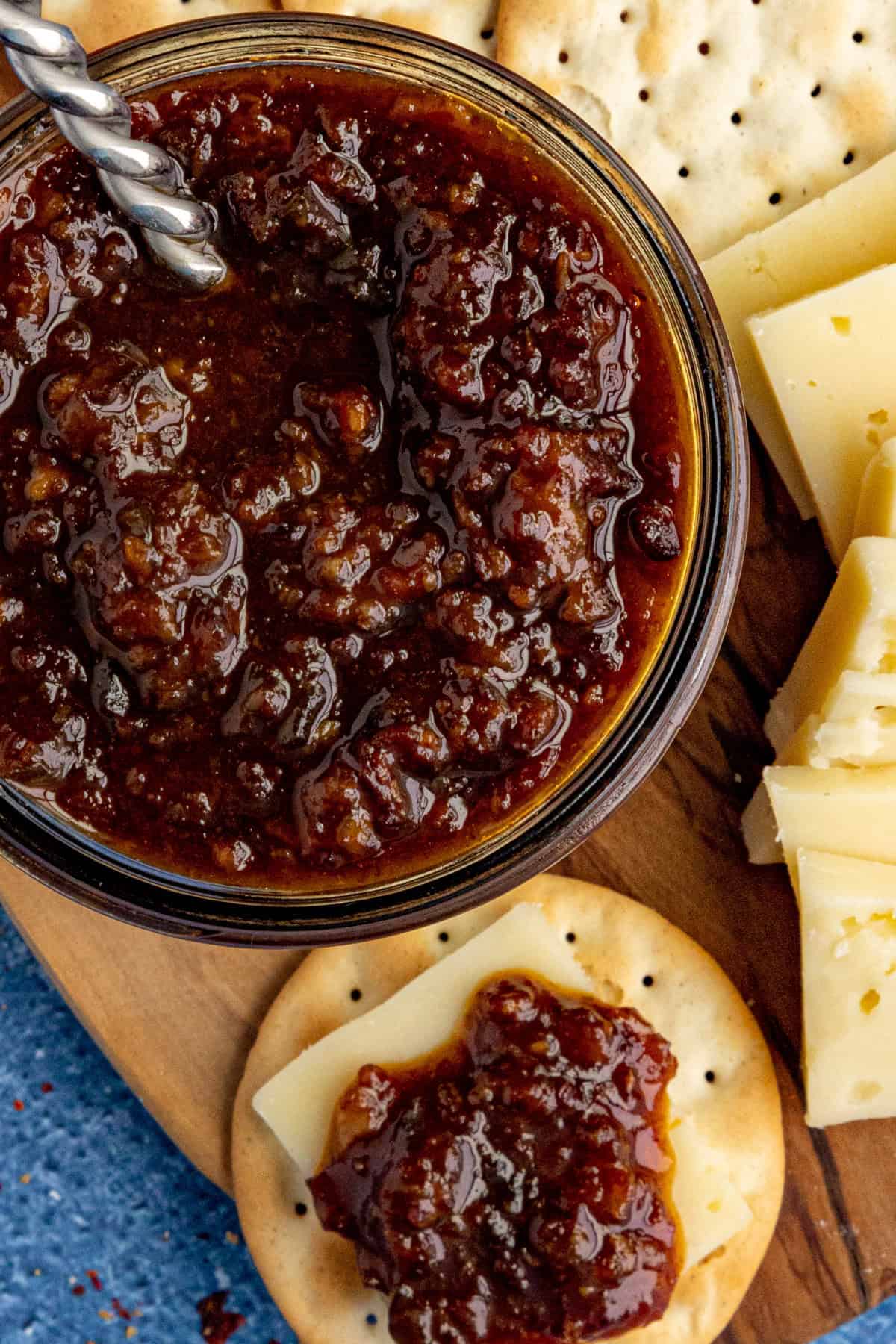 A jar filled with delicious Bacon Jam served on crackers