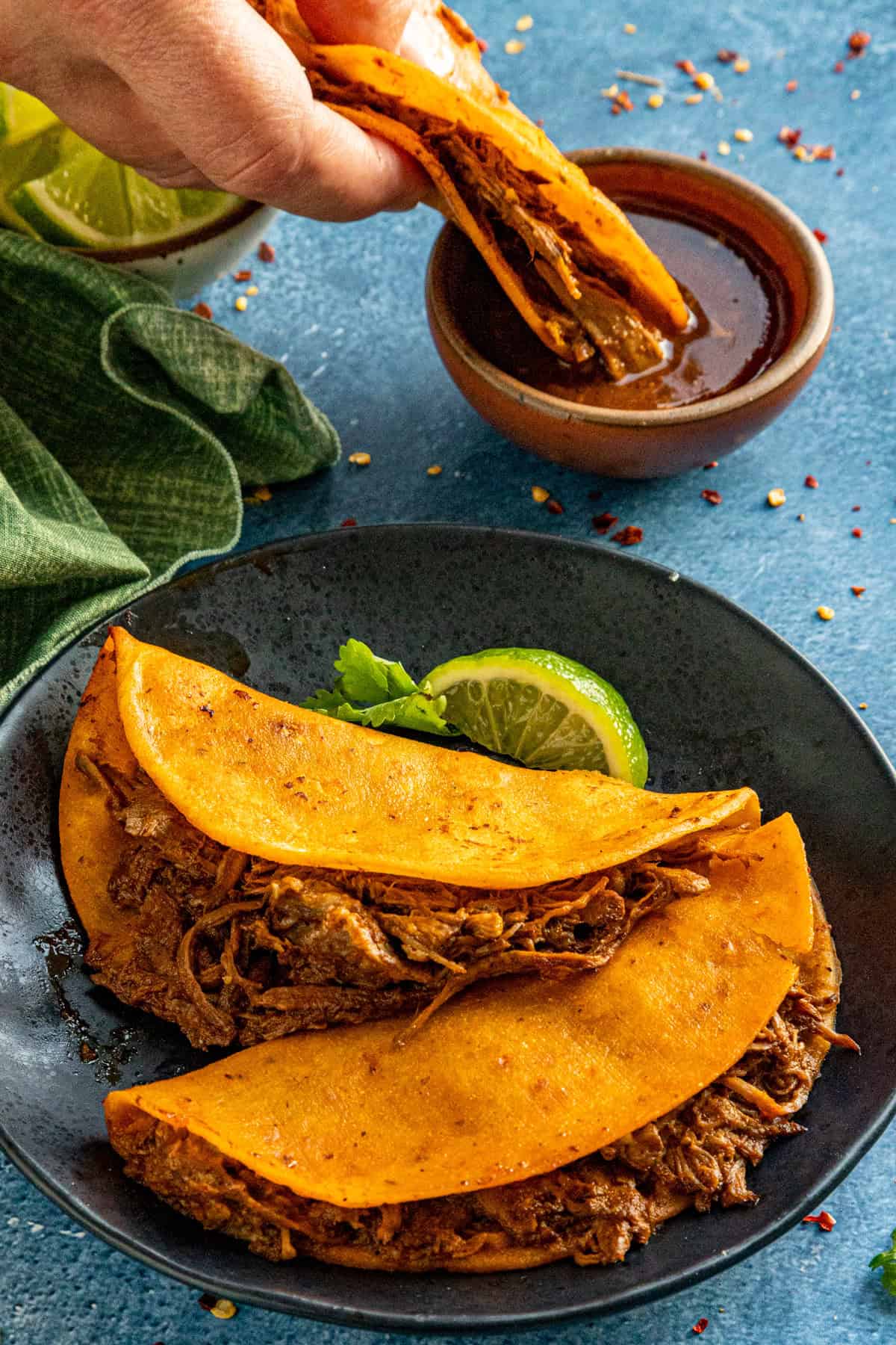 Mike dipping a birria taco into a bowl of birria sauce (consome)