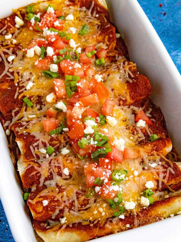 Cheese enchiladas with chopped tomato and green onion - easy, melty, and loaded with bold flavor.