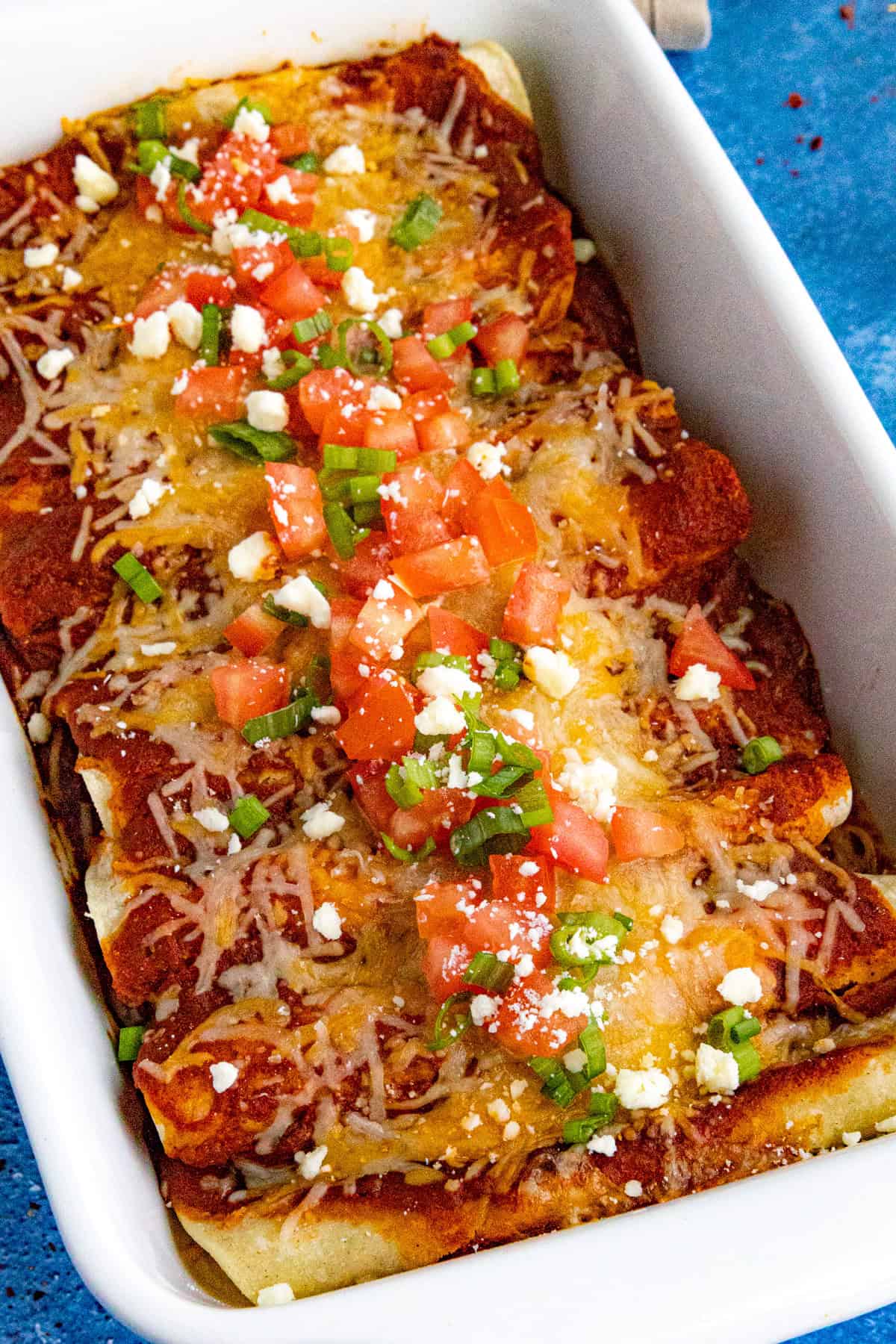 Cheese enchiladas with chopped tomato and green onion - easy, melty, and loaded with bold flavor.