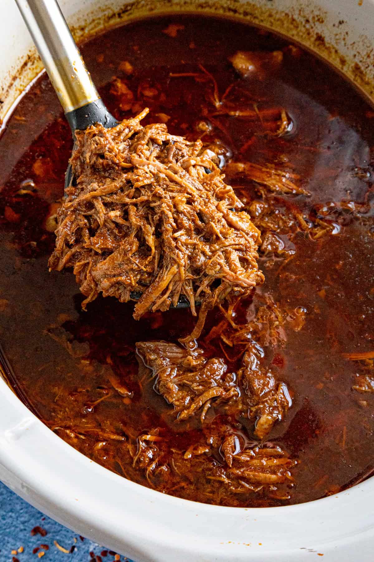Mike serving a scoop of tender Mexican Birria from the slow cooker (crockpot)