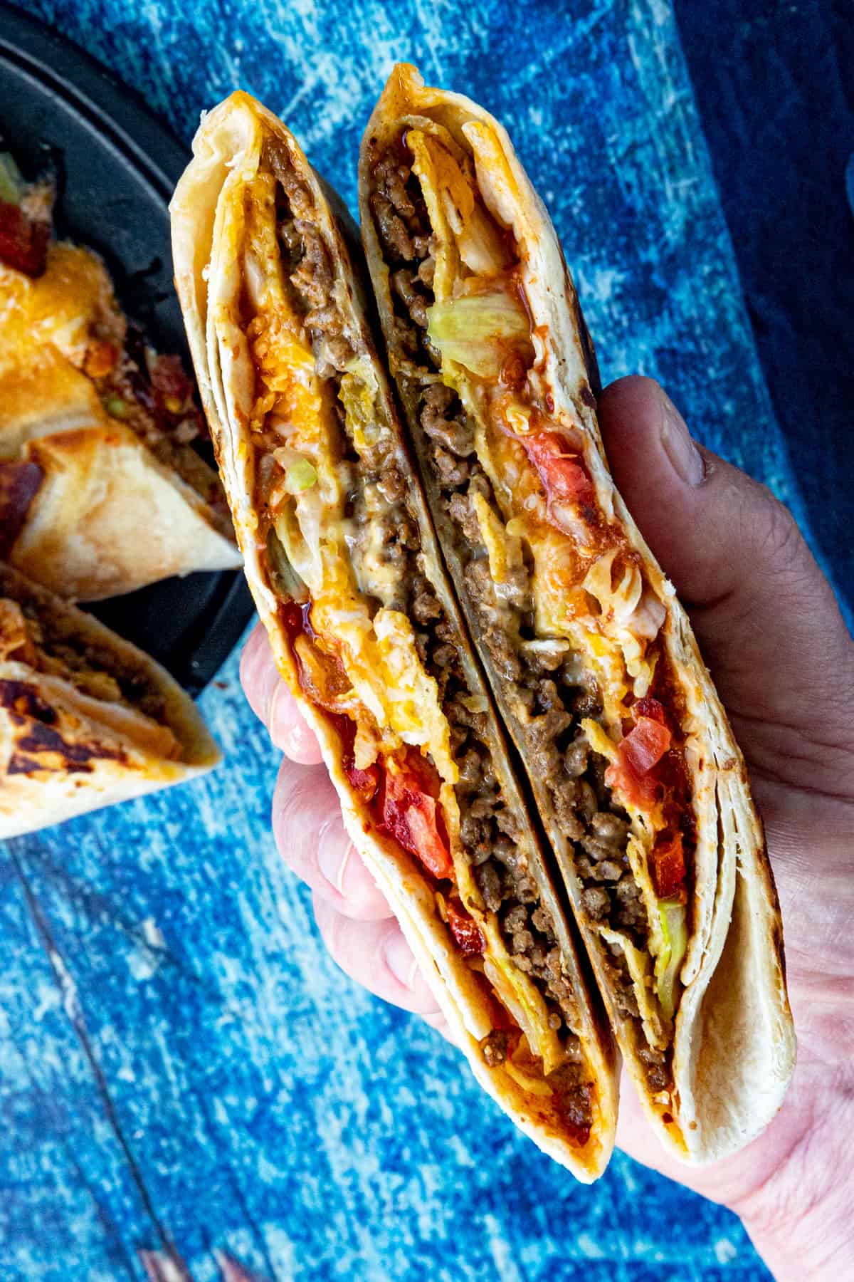 Mike holding a Homemade Crunchwrap Supreme folded into 2 pieces