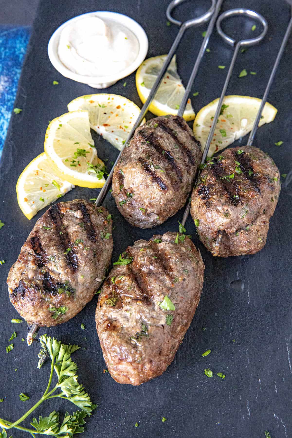 Kofta Kebabs on a platter, served with lemon wedges and tahini sauce