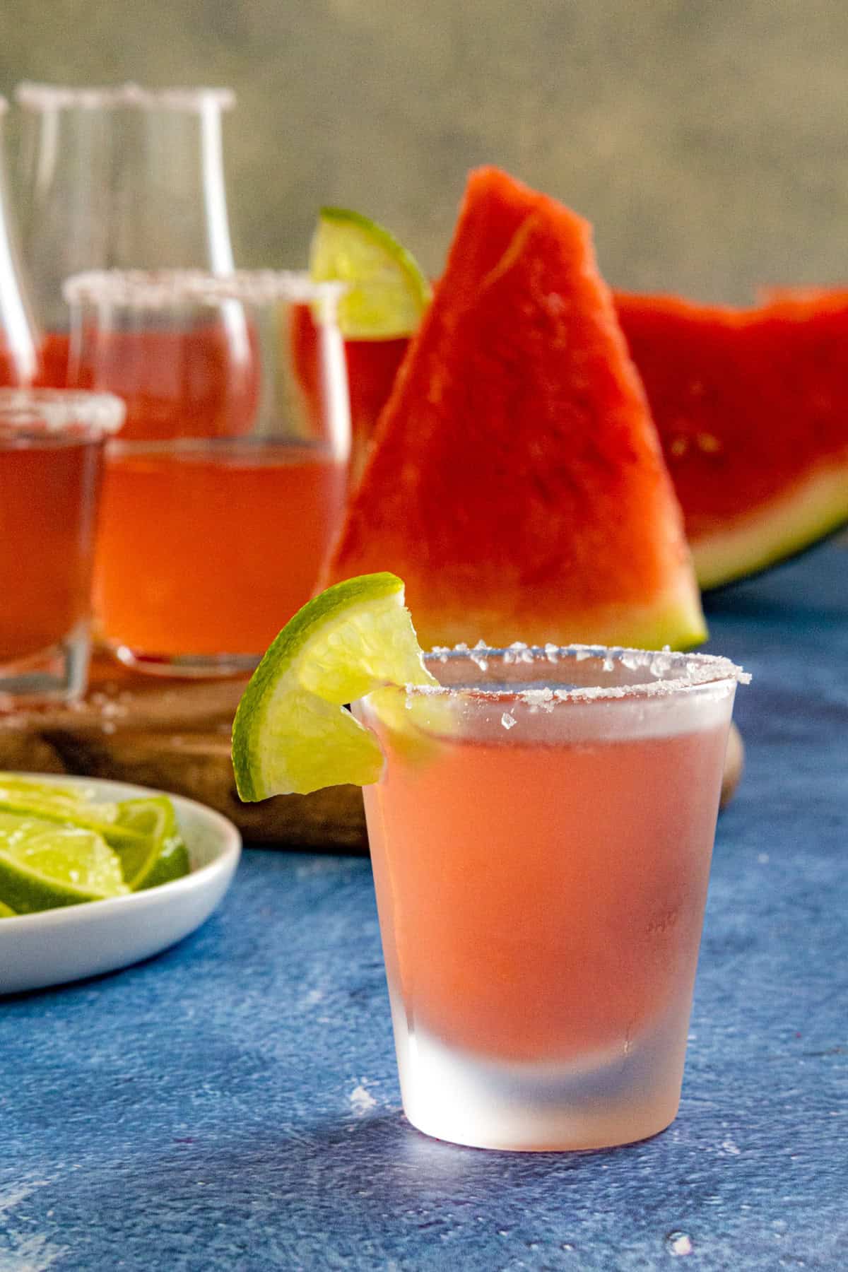 A Mexican Candy Shot in a shot glass with salt rim and lime wedge