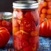 A large jar of Pickled Tomatoes on a table