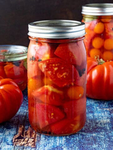 A large jar of Pickled Tomatoes on a table