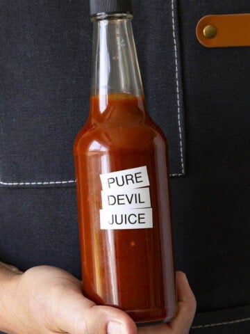 Mike holding a bottle of fiery Pure Devil Juice hot sauce