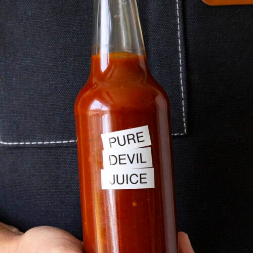 Mike holding a bottle of fiery Pure Devil Juice hot sauce