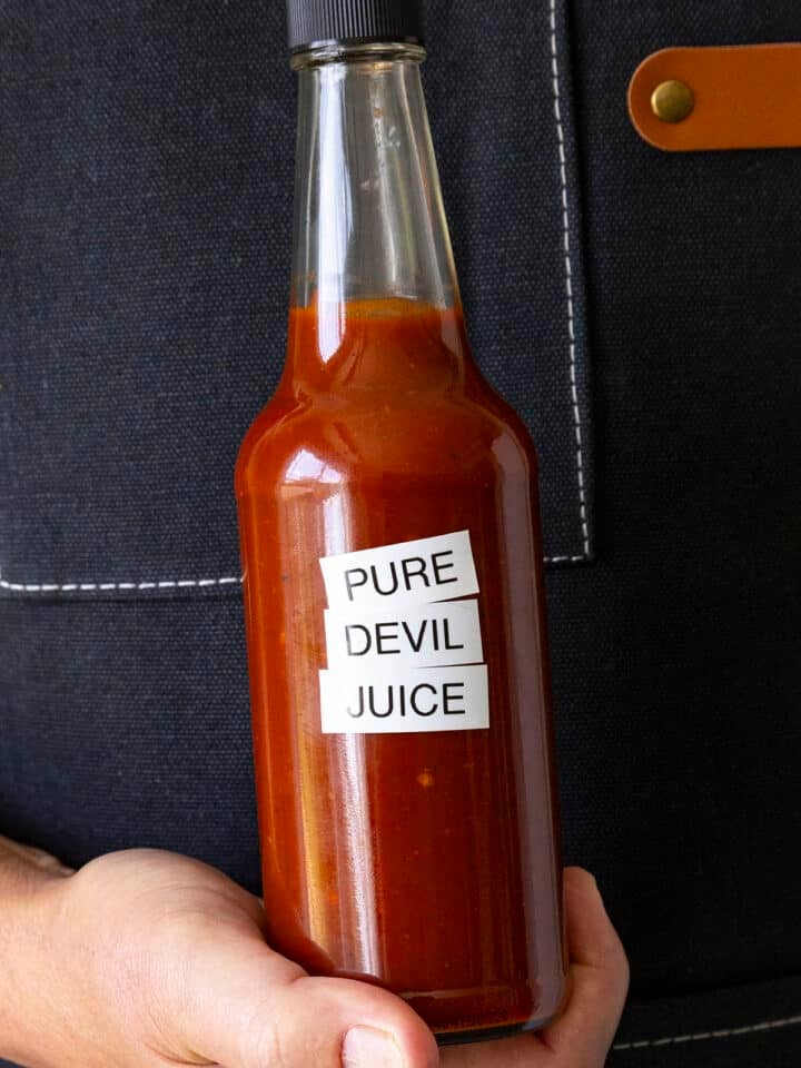 Mike holding a bottle of fiery Pure Devil Juice hot sauce