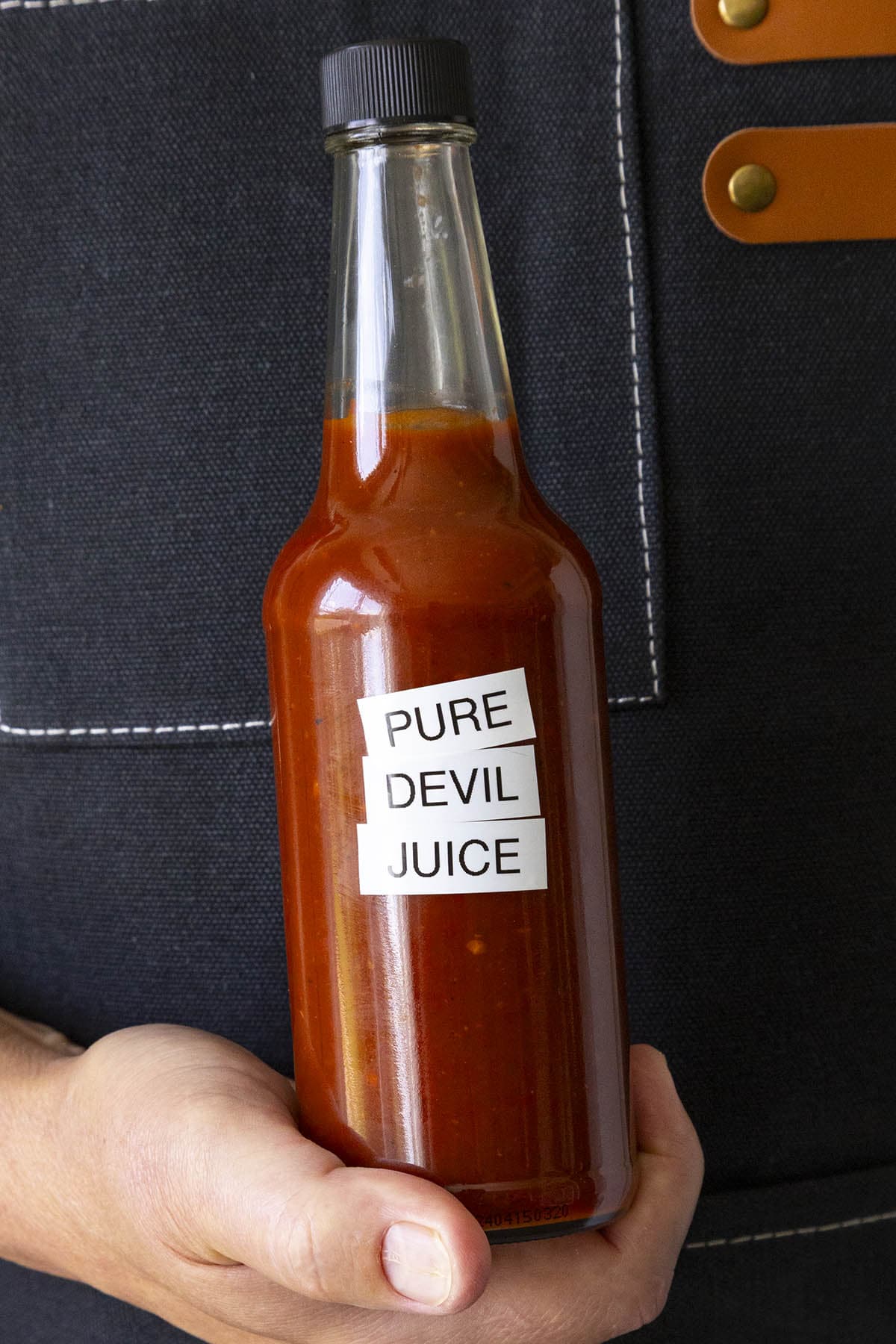 Mike holding a bottle of fiery Pure Devil Juice hot sauce