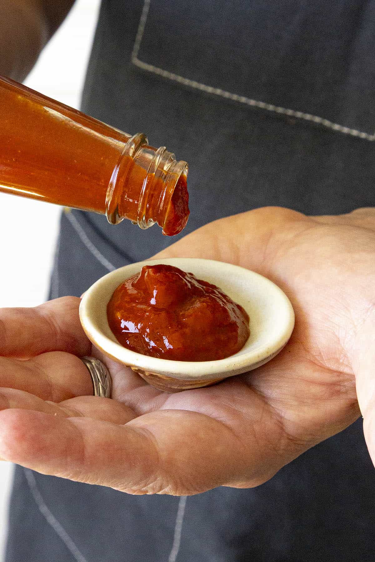 Mike pouring Pure Devil Juice hot sauce